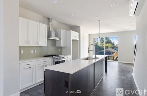 A modern kitchen with white cabinets and a large island.
