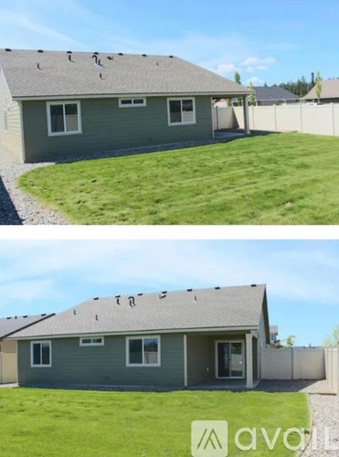 A house with a grey roof and a green lawn.