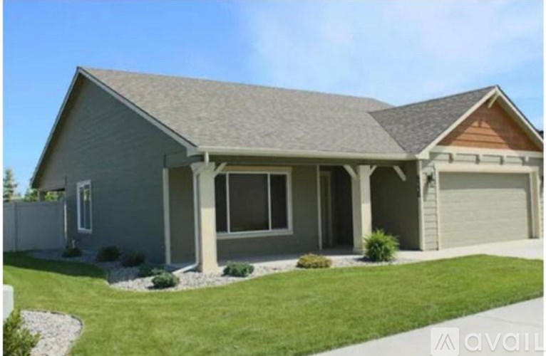 A house with a grey roof and a garage door.