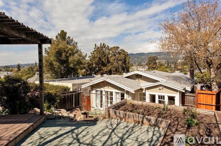 A house with a brown fence and a tree in front of it.