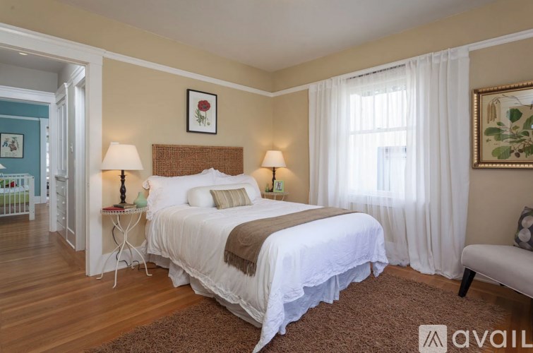 A bedroom with a large bed and a painting on the wall.