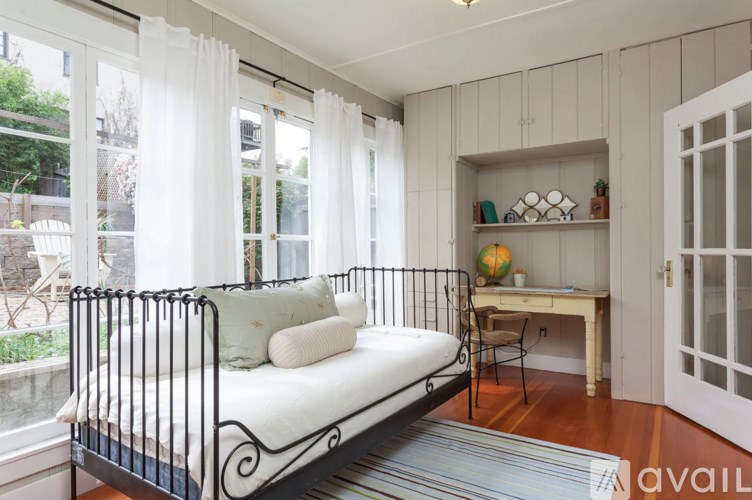 A bedroom with a white bed and a desk with a chair.