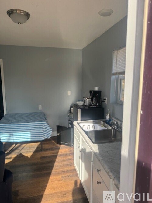 A kitchen with a striped cushion on the floor.