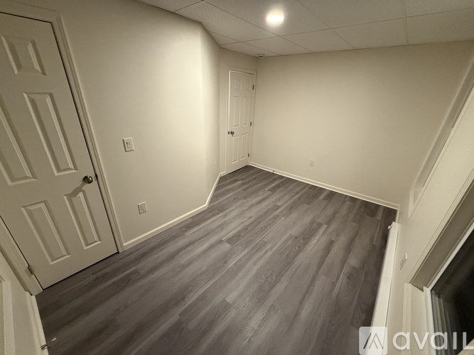 A room with a wooden floor and white walls.