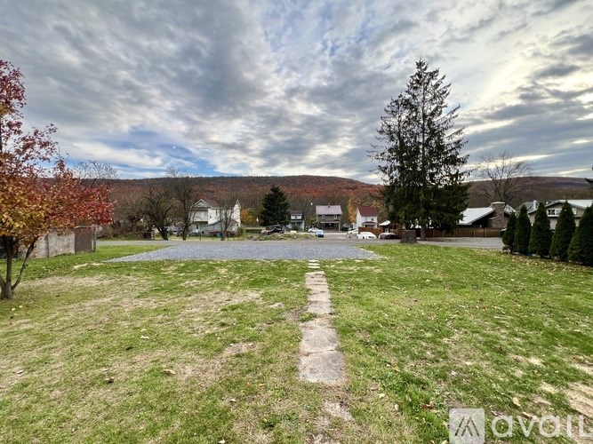 A grassy field with a path in the middle and a tree on the right.