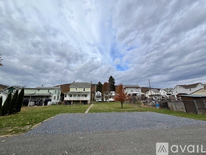 A residential area with houses and a driveway in the foreground.