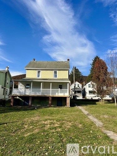 A house with a green lawn and a white fence.