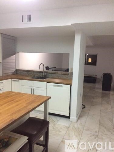 A kitchen with a wooden table and white cabinets.