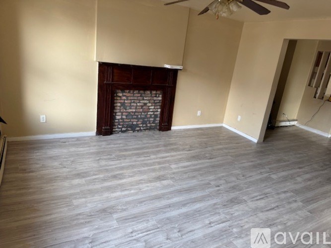 A living room with a fireplace and wood flooring.