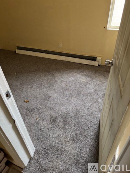 A room with a carpeted floor and a white door.