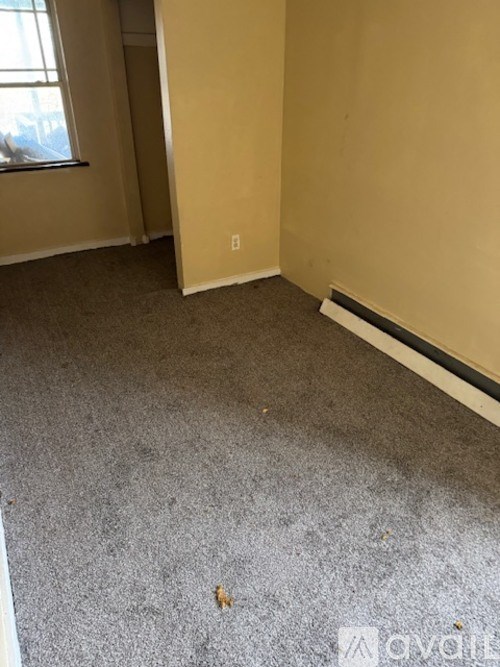 A room with a carpeted floor and a window.