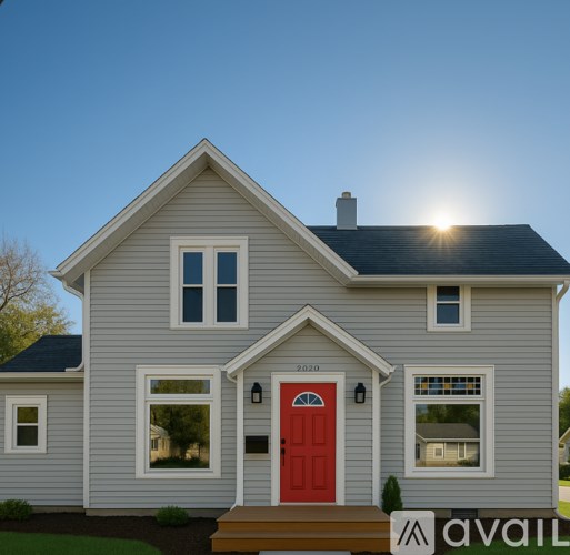 A house with a red door and a sun shining on the roof.