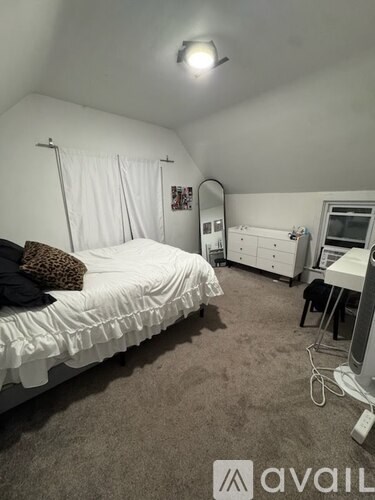 A bedroom with a bed, dresser, and mirror.
