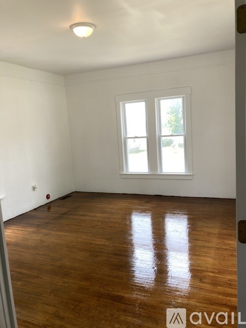 A room with wooden flooring and a window.