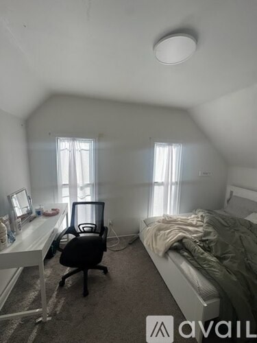 A bedroom with a bed, desk, and chair.
