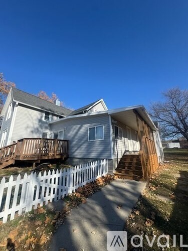 A house with a white picket fence and a deck.