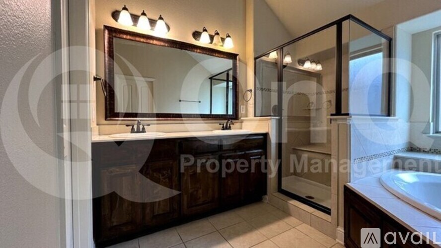 A bathroom with a sink, mirror, and shower.