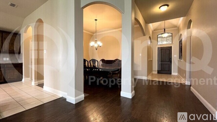A spacious living room with a fireplace and a chandelier.