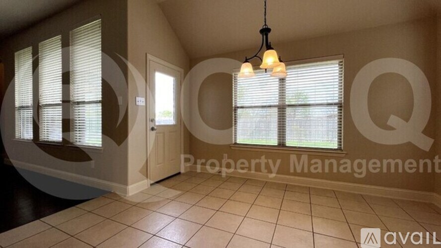 A room with a brown floor and a white door is available for rent.