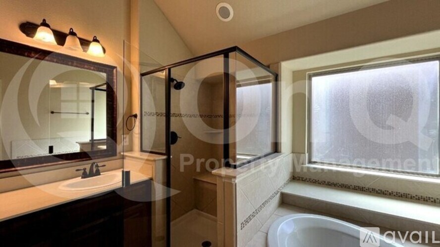 A bathroom with a sink, mirror, and shower.