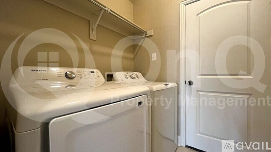 Two white front load washing machines in a laundry room.