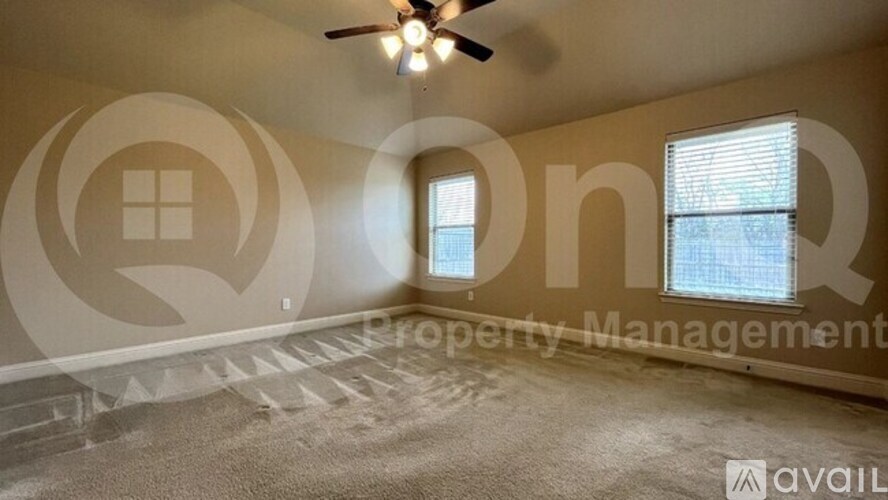 A room with a carpeted floor, a ceiling fan, and a window with blinds.