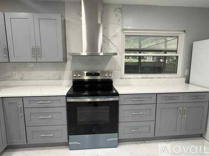 A kitchen with a stove top oven and cabinets.