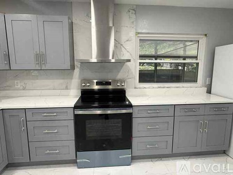 A kitchen with a stove top oven and cabinets.