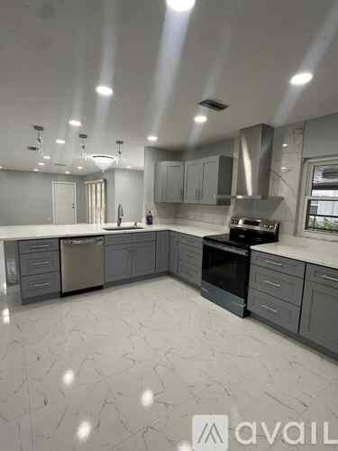 A spacious kitchen with a marble floor and modern appliances.
