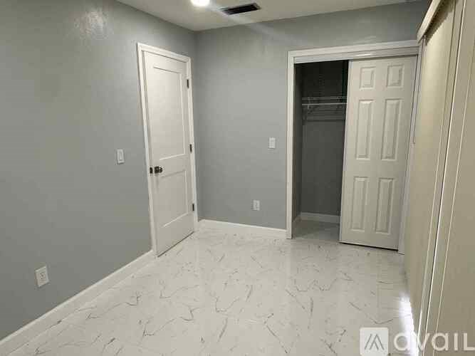 A room with a marble floor and two doors.