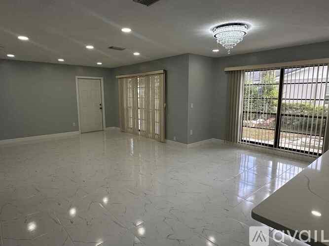 A spacious room with a marble floor and a ceiling light fixture.