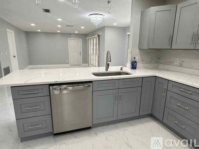 A kitchen with a marble countertop and stainless steel appliances.