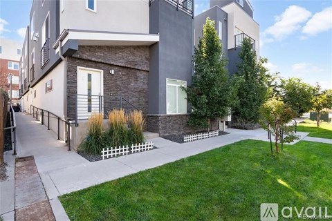 A modern house with a well-maintained lawn and a white picket fence.