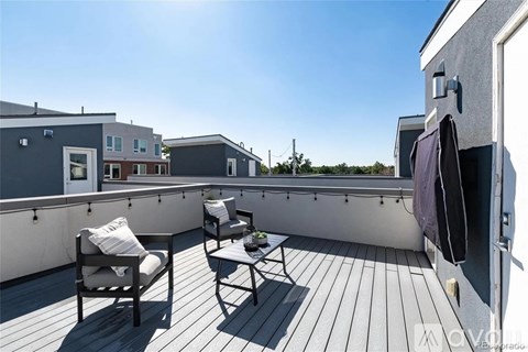 A balcony with two chairs and a table.