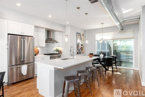 A modern kitchen with a large island and stools.