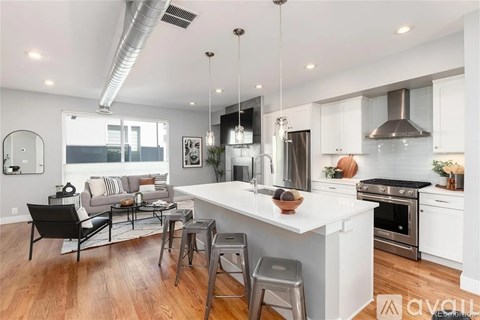 A modern kitchen with a white island and stainless steel appliances.