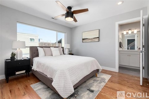 A bedroom with a large bed and a ceiling fan.