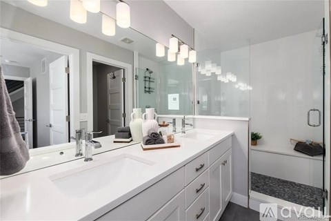 A bathroom with a white countertop and a large mirror above the sink.