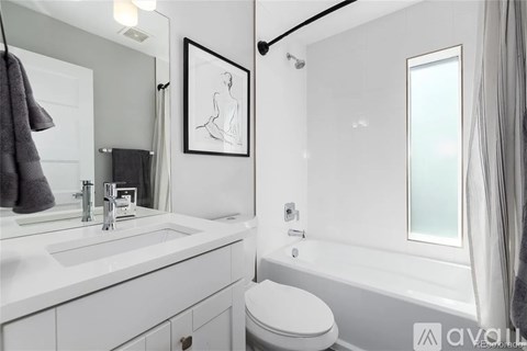 A bathroom with a toilet, sink, and bathtub.