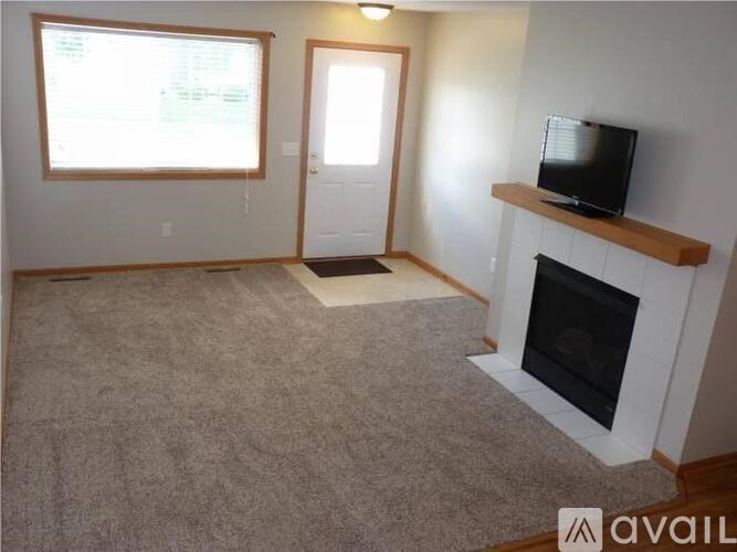 A living room with a fireplace and a television on the wall.