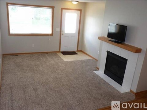 A living room with a fireplace and a television on the wall.
