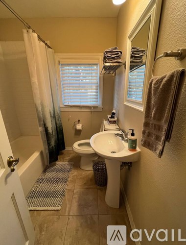 A bathroom with a toilet, sink, and shower.