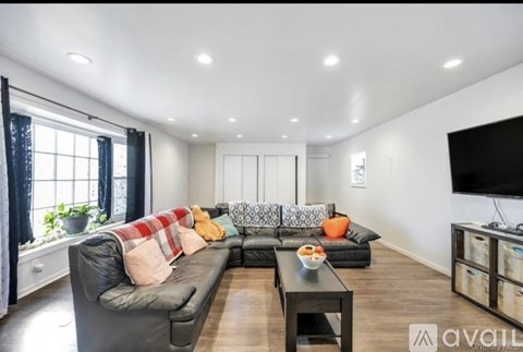 A living room with a grey sofa and a black coffee table.