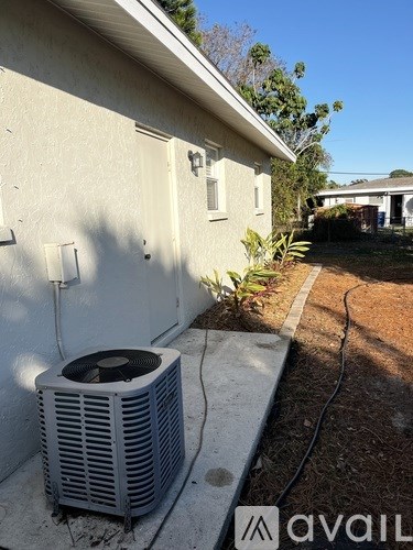 A wall-mounted air conditioning unit is outside a house.
