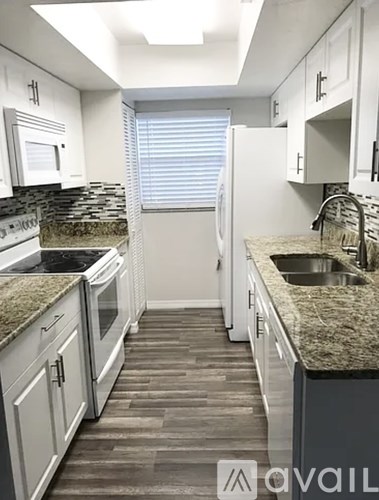 A kitchen with granite countertops and white cabinets.