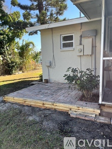 A small white house with a wooden deck in front.