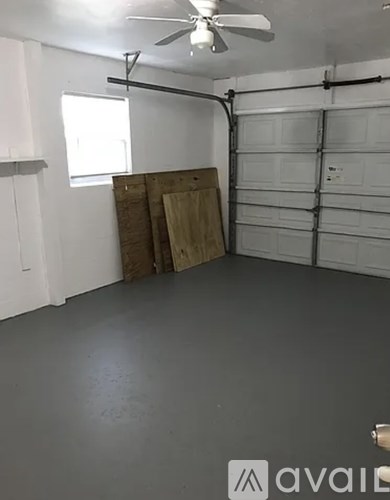 A room with a ceiling fan and a garage door.