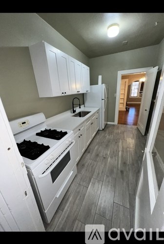 A kitchen with white appliances and cabinets.