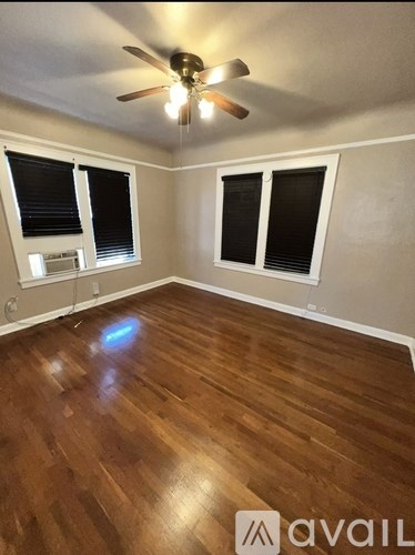 A room with wooden floors and a ceiling fan.