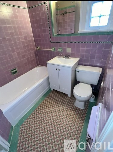 A bathroom with purple tiles and a white bathtub.